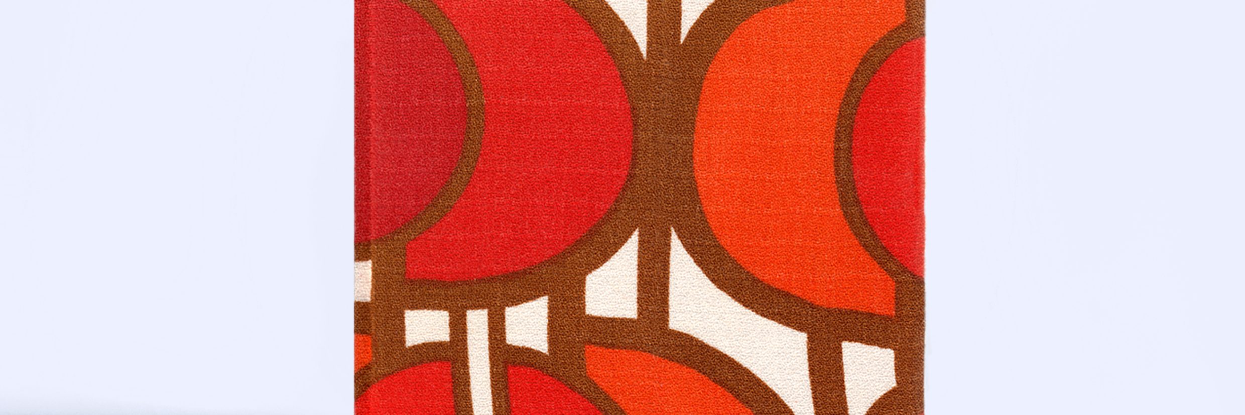 Studioaufnahme von einem Buchcover mit rot-orangen Stoffbezug aus den 70iger Jahren, vor einem hellblauen Hintergrund.